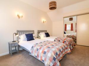 a bedroom with two beds and a mirror at Elm Tree Cottage in Melton Mowbray