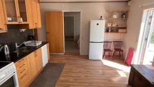 EllösにあるEllös Holiday apartmentのキッチン(白い冷蔵庫、木製キャビネット付)