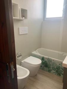 a bathroom with a toilet and a tub and a sink at Blu Sun Apartment in Complesso Riva del Sole in Giovinazzo