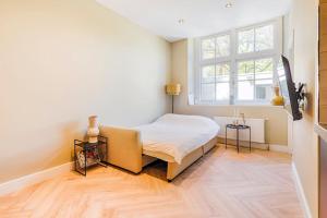 a small bedroom with a bed and a window at Old Town City Centre Apartment in Nijmegen