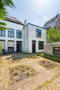 a large white house with a courtyard in front of it at Old Town City Centre Apartment in Nijmegen