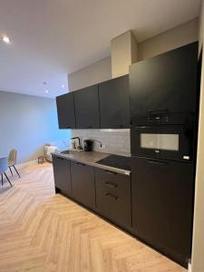 a kitchen with black appliances and a wooden floor at Old Town City Centre Apartment in Nijmegen