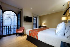 um quarto de hotel com uma cama e uma varanda em Áurea Catedral by Eurostars Hotel Company em Granada
