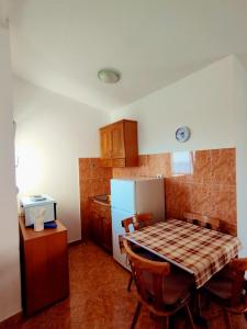 eine kleine Küche mit einem Tisch und einem Kühlschrank in der Unterkunft Joksimović apartmani in Šušanj