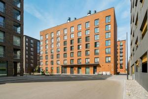 a large red brick building with a lot of windows at Hiisi Homes Turku Herttuankulma in Turku