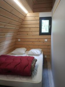 a bedroom with a bed in a wooden cabin at Camping le Pré Morjal in Ispagnac