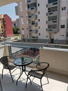 a patio with a table and chairs on a balcony at Apartman Rosić in Trebinje