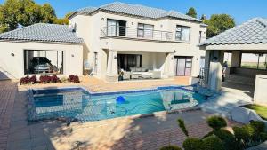 a house with a swimming pool in front of a house at The Hide in Sandton in Johannesburg