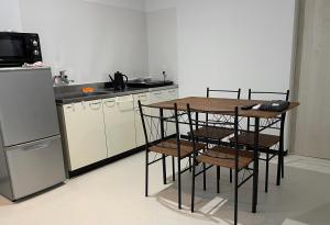 een keuken met een tafel, stoelen en een koelkast bij Zenibako House 1f in Otaru