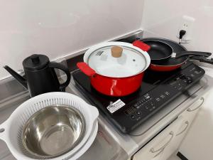 een kookplaat met twee potten en pannen erop bij Zenibako House 1f in Otaru +10 foto's