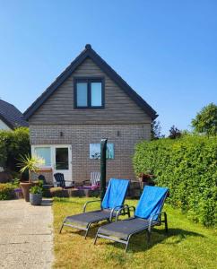 twee blauwe stoelen voor een huis bij Vakantiehuis 't Hertenkamp in Ouddorp