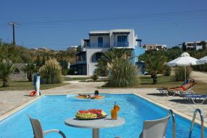a man in a pool with a tray of fruit on a table at Agyra Studios in Agios Prokopios