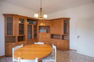 a dining room with a wooden table and cabinets at Da Tina in Portoferraio