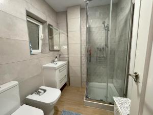 y baño con ducha, aseo y lavamanos. en Edificio Amarillo en el Barrio, en Alicante