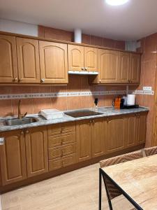 a kitchen with wooden cabinets and a sink and a table at HOSTER EGYPT VERONA centro de Tomelloso in Tomelloso +13 photos