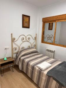 1 dormitorio con cama y espejo en la pared en HOSTER EGYPT VERONA, en Tomelloso