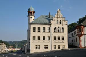 a large white building with a tower on top of it at Apartmán Kryštof - Jáchymov in Jáchymov