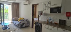 uma cozinha com uma sala de estar com um sofá em Hawana lagoon Salala - SL28 em Salalah