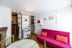 a living room with a red couch and a table at Appartement Pieds des Pistes in Saint-Lary-Soulan