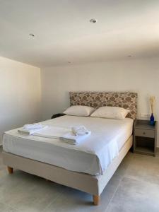 a bedroom with a large bed with two towels on it at Aristidis Garden in Parga
