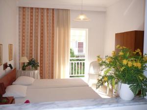 a hotel room with two beds and a window at Apartments Juli in Nea Potidaea