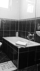 ein Badezimmer mit einer Badewanne und einem Waschbecken in der Unterkunft Joksimović apartmani in Šušanj