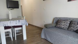 una sala de estar con un sofá y una mesa en Apartman Greta Sukošan, en Sukošan
