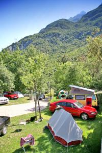 een tent en een auto geparkeerd in een veld bij Camping Alpino - Nature Village in Malcesine
