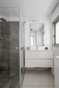 a bathroom with a sink and a glass shower at Mate TLV PORT - By HOMY in Tel Aviv