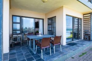 eine Terrasse mit einem blauen Tisch und Stühlen in der Unterkunft Sancta South Coast 2 bedroom Apartment in Kingsborough