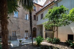 a building with a palm tree in front of it at Hotel Posta - palazzo Guidoni in Orvieto