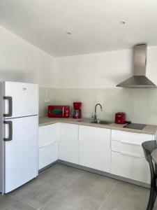 uma cozinha branca com um lavatório e um frigorífico em Aristidis Garden em Parga