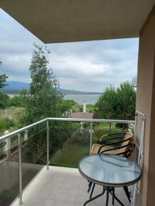 a table and chairs on a balcony with a view of the ocean at Santa Maria Apartments in Ahtopol