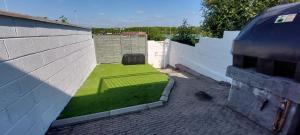 a small yard of grass on the side of a building at Modern City Centre House in Heart of Galway City in Galway
