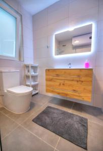 La salle de bains est pourvue de toilettes, d'un lavabo et d'un miroir. dans l'établissement Spacious & Tastefully furnished 3 bedrooms RCUT1-1, à Is-Swieqi