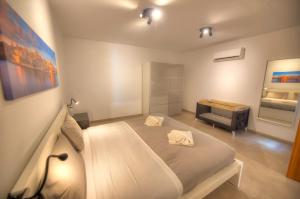una camera con un grande letto e una sedia di Spacious & Tastefully furnished 3 bedrooms RCUT1-1 a Is-Swieqi