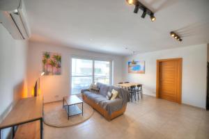 ein Wohnzimmer mit einem Sofa und einem Tisch in der Unterkunft Spacious & Tastefully furnished 3 bedrooms RCUT1-1 in Is-Swieqi