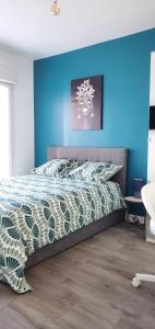 1 dormitorio con 1 cama con pared azul en Charming Room with shared space close to PARIS - Chambres Confort avec espaces partagés proche de PARIS, en Vitry-sur-Seine