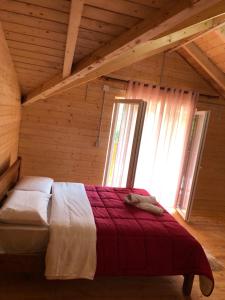 a bedroom with a bed in a wooden room at Livadhi Guesthouse in Mollʼ e Shoshit