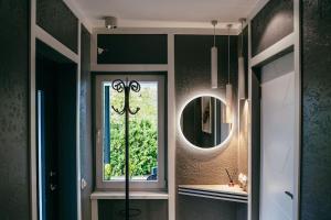 a bathroom with a mirror and a sink and a window at Villa Fortuna in Ludza