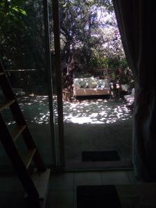eine offene Tür zu einer Terrasse mit einem Sofa im Freien in der Unterkunft Sous les pins in Villeneuve-lès-Avignon