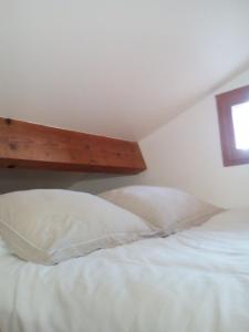 ein Schlafzimmer mit zwei weißen Kissen auf einem Bett in der Unterkunft Sous les pins in Villeneuve-lès-Avignon