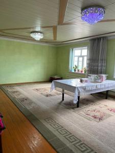 uma sala de estar com uma mesa e uma janela em Guest house В гостях у Лаззат em Türkistan
