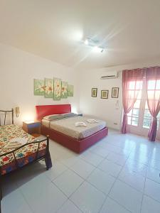 1 dormitorio con 2 camas y ventana en Salento Apartment, en Lizzanello