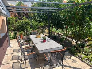 een tafel en stoelen op een patio onder een pergola bij Apartments Nela in Podstrana