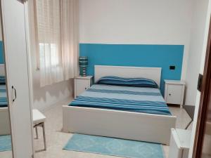 una piccola camera con un letto con una parete blu di Mare e Sabbia ad Alghero