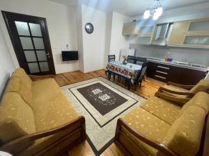 a living room with a couch and a table and a kitchen at Leones Villa in Pogradec