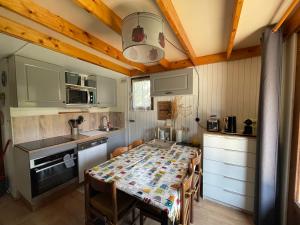 a kitchen with a table and chairs in a kitchen at Chalet confort • Barcelonnette in Barcelonnette
