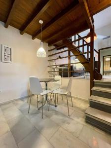 ein Esszimmer mit einem Tisch, Stühlen und einer Treppe in der Unterkunft Embrujo in Granada
