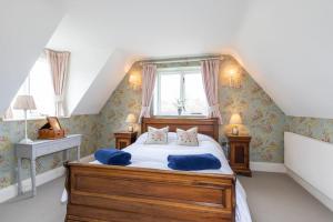 Un dormitorio con una cama con almohadas azules. en Country Manor House near Tetbury, en Malmesbury